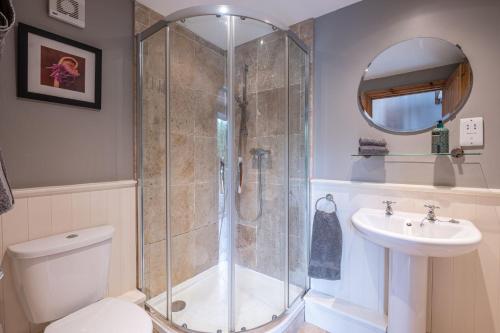 a bathroom with a shower and a toilet and a sink at Waterside Cottage in Harrogate