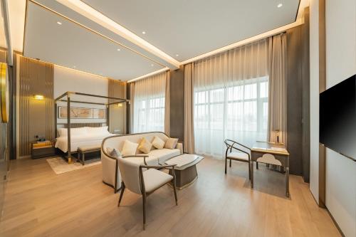 uma sala de estar com um sofá e uma cama em Holiday Inn Zhengzhou Zhongzhou, an IHG Hotel em Zhengzhou