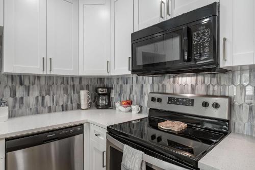 a kitchen with a stove and a microwave at Updated Waterfront Condo in Apollo Beach in Apollo Beach