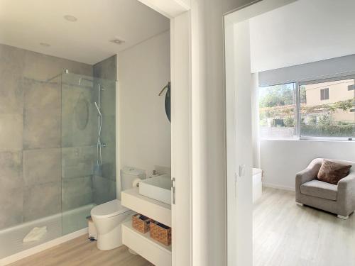 a bathroom with a shower and a toilet and a chair at Uptown Apartment by LovelyStay in Funchal