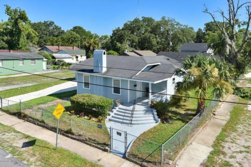 a blue house with a fence in front of it at The Jewel of Jacksonville in Jacksonville