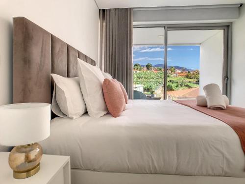 a bedroom with a large bed with a large window at Uptown Apartment by LovelyStay in Funchal