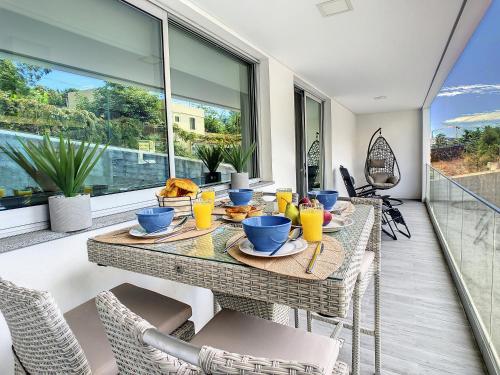 a dining room with a table and chairs on a balcony at Uptown Apartment by LovelyStay in Funchal