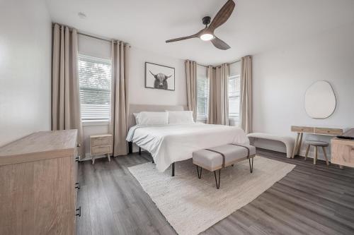 a white bedroom with a bed and a ceiling fan at New Construction Located in Ybor City! in Tampa
