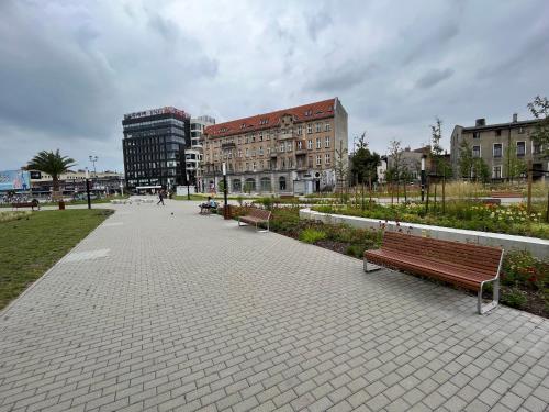 einen Park mit Bänken und Gebäuden in einer Stadt in der Unterkunft Apartament Centrum-Zwycięstwa in Gliwice