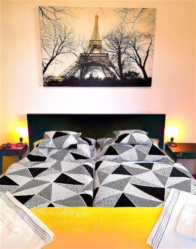 a bedroom with a bed with the eiffel tower at D16 Apartman in Szentgotthárd