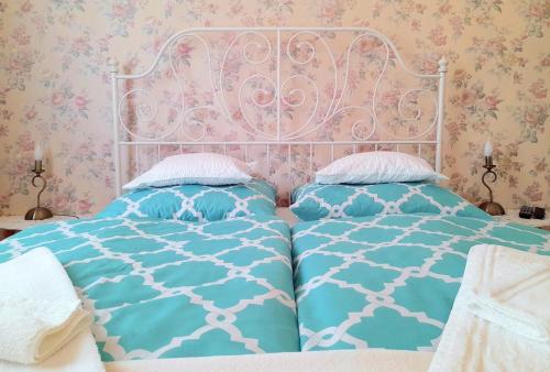 a bedroom with a bed with a white and blue comforter at D16 Apartman in Szentgotthárd