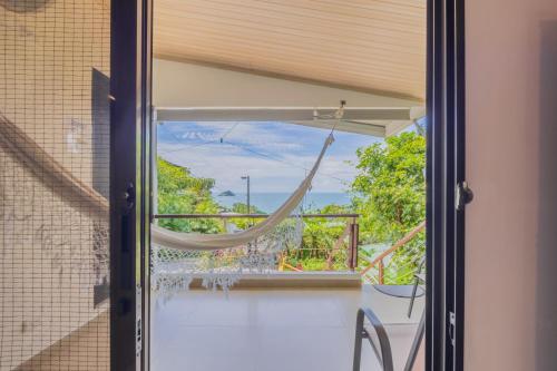 a glass door with a hammock on a balcony at Hotel Villas de la Selva in Manuel Antonio