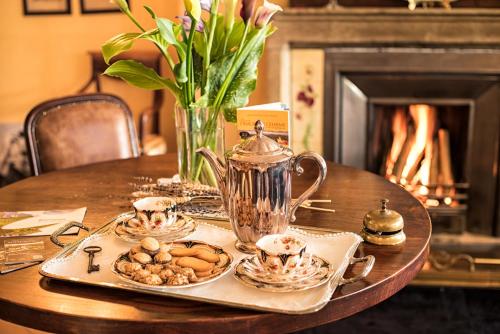 a table with plates of food and a tea kettle at Villa Bricco dei Cogni in La Morra