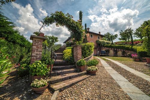 a garden with stairs and an arch with potted plants at Villa Bricco dei Cogni in La Morra
