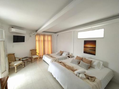 um quarto de hotel com duas camas e uma televisão em Casa Ego em Cartagena de Indias