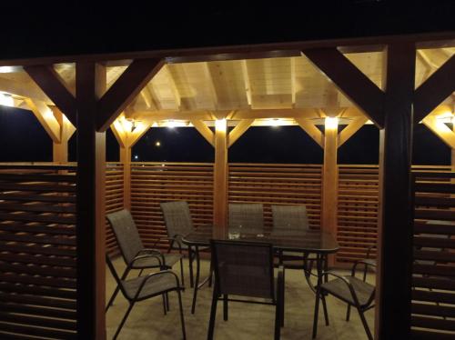 a patio with a table and chairs and lights at Domki na Wierchu - z widokiem na góry in Białka Tatrzanska