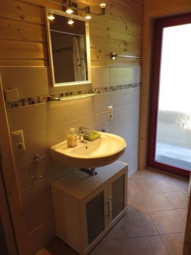ein Bad mit einem Waschbecken und einem Spiegel in der Unterkunft EifelGlückVII in Rieden