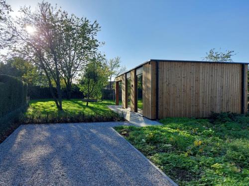 a house with a wooden fence and a walkway at Geniet van alle comfort tussen Ieper en Heuvelland in Ieper