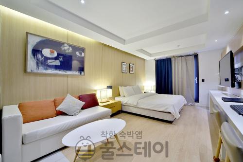 a living room with a couch and a bed at Golden Hotel Incheon in Incheon