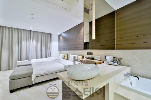 a bathroom with a bed and a sink in a room at Golden Hotel Incheon in Incheon