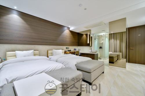 a hotel room with two beds and a desk at Golden Hotel Incheon in Incheon