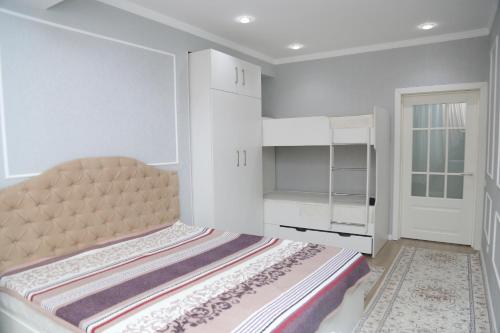 ein weißes Schlafzimmer mit einem Bett und einem weißen Schrank in der Unterkunft Апартаменты в центре Бишкека in Bischkek