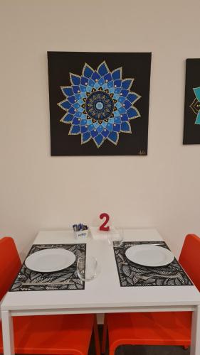 a white table with two chairs and a picture on the wall at LITHOS ROOMs in Matera
