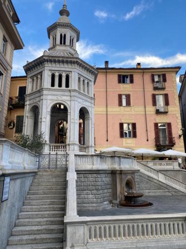 un edificio con una escalera frente a un edificio en Appartamento Lella zona Terme Centro e vicino Villa Igea sito in Via Emilia 29, en Acqui Terme