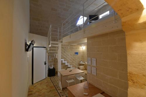 una camera con scala e muro di mattoni di Comera a Matera