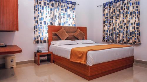 a bedroom with a bed with a wooden headboard at Da Inn Home Stay in Garacherāma