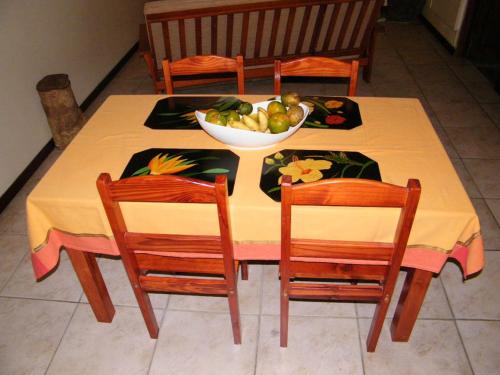 a table with two chairs and a bowl of fruit at Maison charmante à Gros-Morne avec terrasse et jardin in Gros-Morne