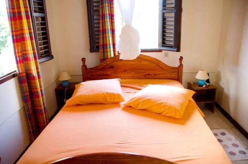 um quarto com uma cama com duas almofadas em Maison de 2 chambres avec terrasse amenagee et wifi a Gros Morne em Gros-Morne
