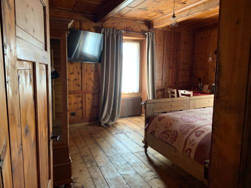 a bedroom with a bed and a television in a cabin at AL BAIT DA LUCIA Bormio in Bormio