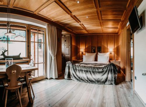 a bedroom with a bed and a desk in a room at Mountain Chalet Pra Ronch in Selva di Val Gardena