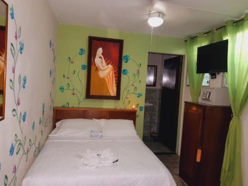 a bedroom with a bed with flowers on the wall at Hotel Oasis in San Salvador