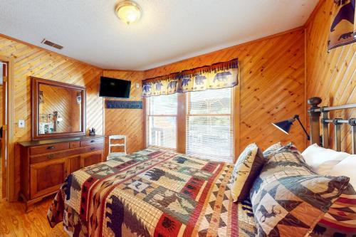 ein Schlafzimmer mit einem Bett, einer Kommode und einem Fenster in der Unterkunft Mountain Memories in Gatlinburg