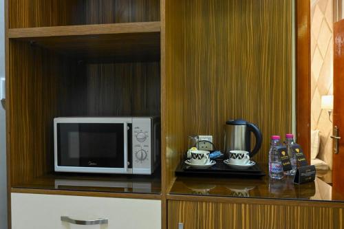 a microwave sitting on a shelf in a cabinet at جوهرة السراة للأجنحة الفندقية in Khamis Mushayt