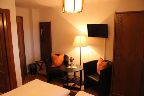 a hotel room with two chairs and a table and a lamp at Pension Wolfgangsee in St. Wolfgang
