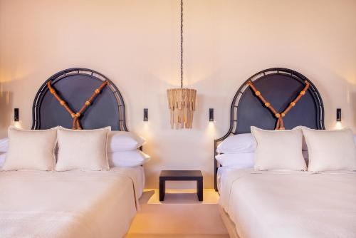 two beds with white pillows in a room at Kimpton Mas Olas Resort and Spa in Todos Santos