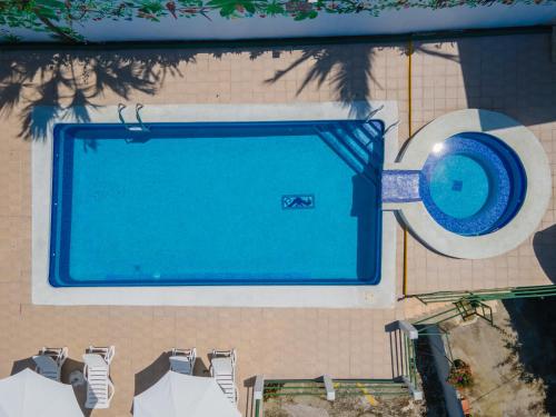 an overhead view of a swimming pool with chairs at Hotel Villas de la Selva in Manuel Antonio