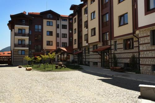 a city street with tall buildings in the background at Winslow Highland Bansko - Apartment Giovanni, ул Валевица 7 кв Грамадето in Bansko