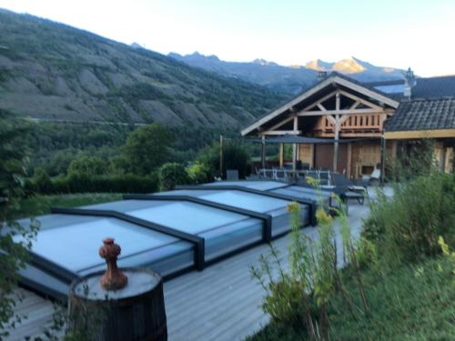 a group of mattresses on a deck in front of a house at Chalet savoyard d'exception avec piscine chauffée in Bourg-Saint-Maurice