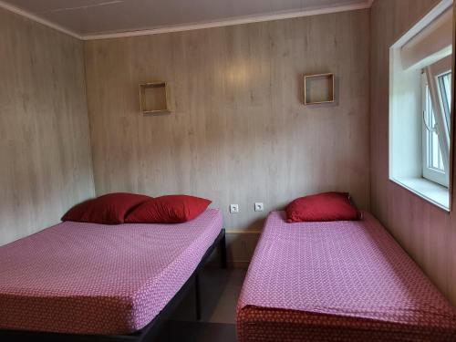 twee bedden in een kamer met rode en roze lakens bij STUDIO ENTRE PARIS et DISNEY 3 in Torcy