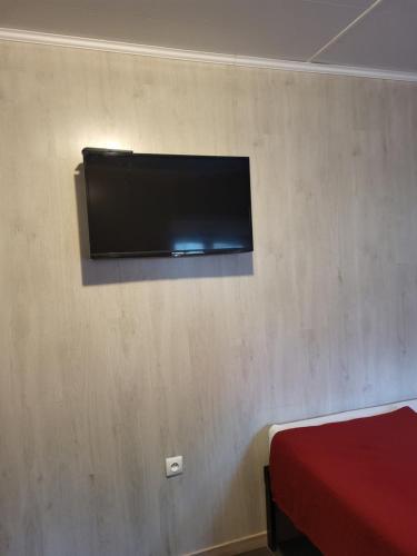 een flatscreen-tv aan een muur in een slaapkamer bij STUDIO ENTRE PARIS et DISNEY 3 in Torcy