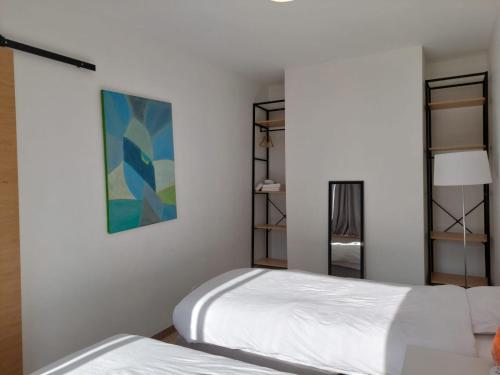 a bedroom with two beds and a painting on the wall at Paris beaugrenelle: charmante résidence in Paris