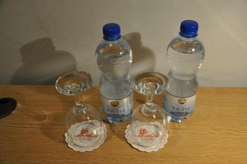 three bottles and two wine glasses on a table at Hotel Löwen in Mellingen