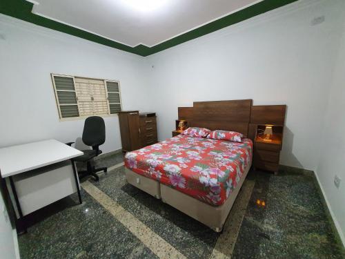 um quarto com uma cama e uma secretária. em Casa Verde em Limeira