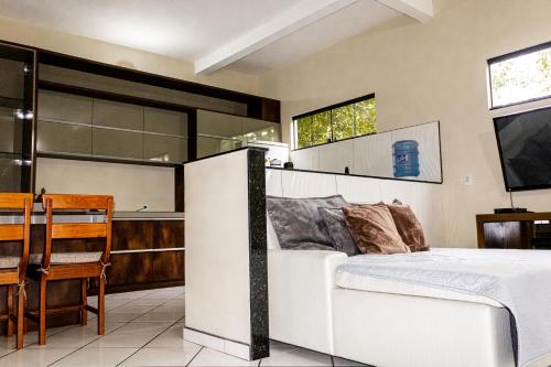 1 dormitorio con 1 cama y cocina con mesa en Guriri Recanto Paneágua cantinho de sossego, en São Mateus