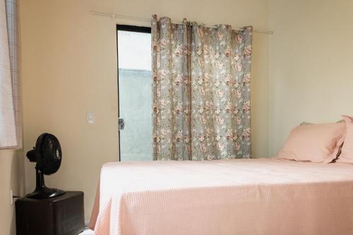 una camera da letto con un letto e una finestra di Guriri Recanto Paneágua cantinho de sossego a São Mateus