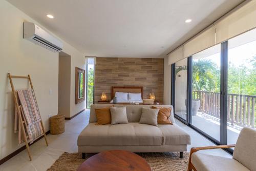 1 dormitorio con sofá, cama y balcón en D101 Beautiful Loft Steps From The Beach - Punta Cocos en Holbox Island