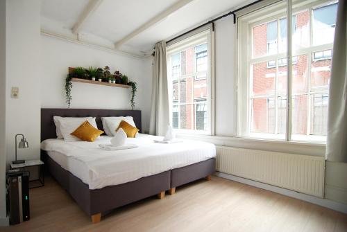 アムステルダムにあるLoft Leidsegrachtのベッドルーム1室(大型ベッド1台、窓2つ付)
