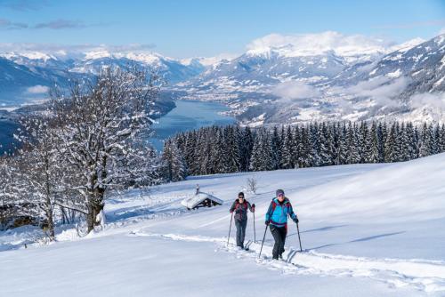 two people on skis in the snow on a mountain at Pension Linder in Seeboden