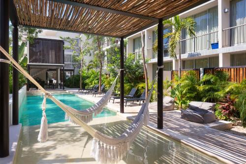 a hammock on a patio next to a swimming pool at Luxury Condo for 4 Casa Azul in Tulum