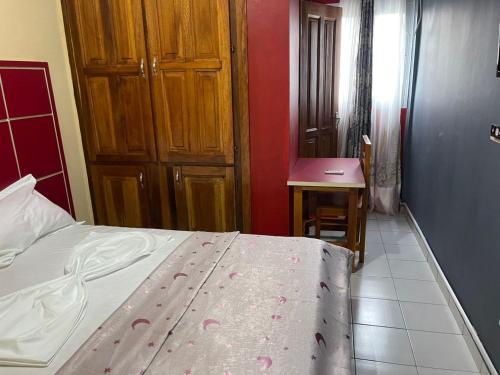 Schlafzimmer mit einem Bett, einem Tisch und einem Schreibtisch in der Unterkunft Complexe Meublé PEPON in Douala